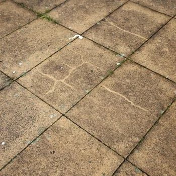 Dirty, cracked paving tiles with visible grime, ideal for pressure washing in Wilmington NC to restore cleanliness and appearance.